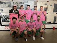 a group of boys in pink shirts posing for a picture