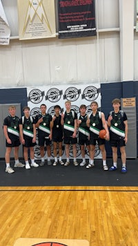 a group of boys posing for a picture on a basketball court