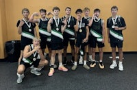 a group of boys posing for a picture with their medals